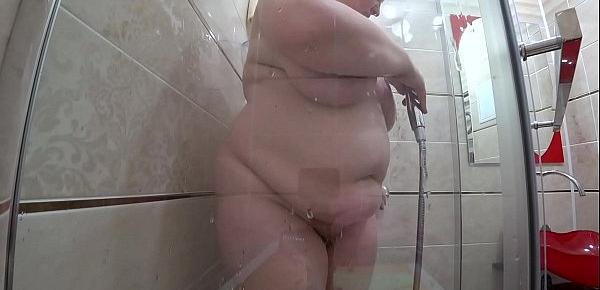  Peeping after the milf who washes in the shower. Mature plump figure with large tits and a juicy butt.